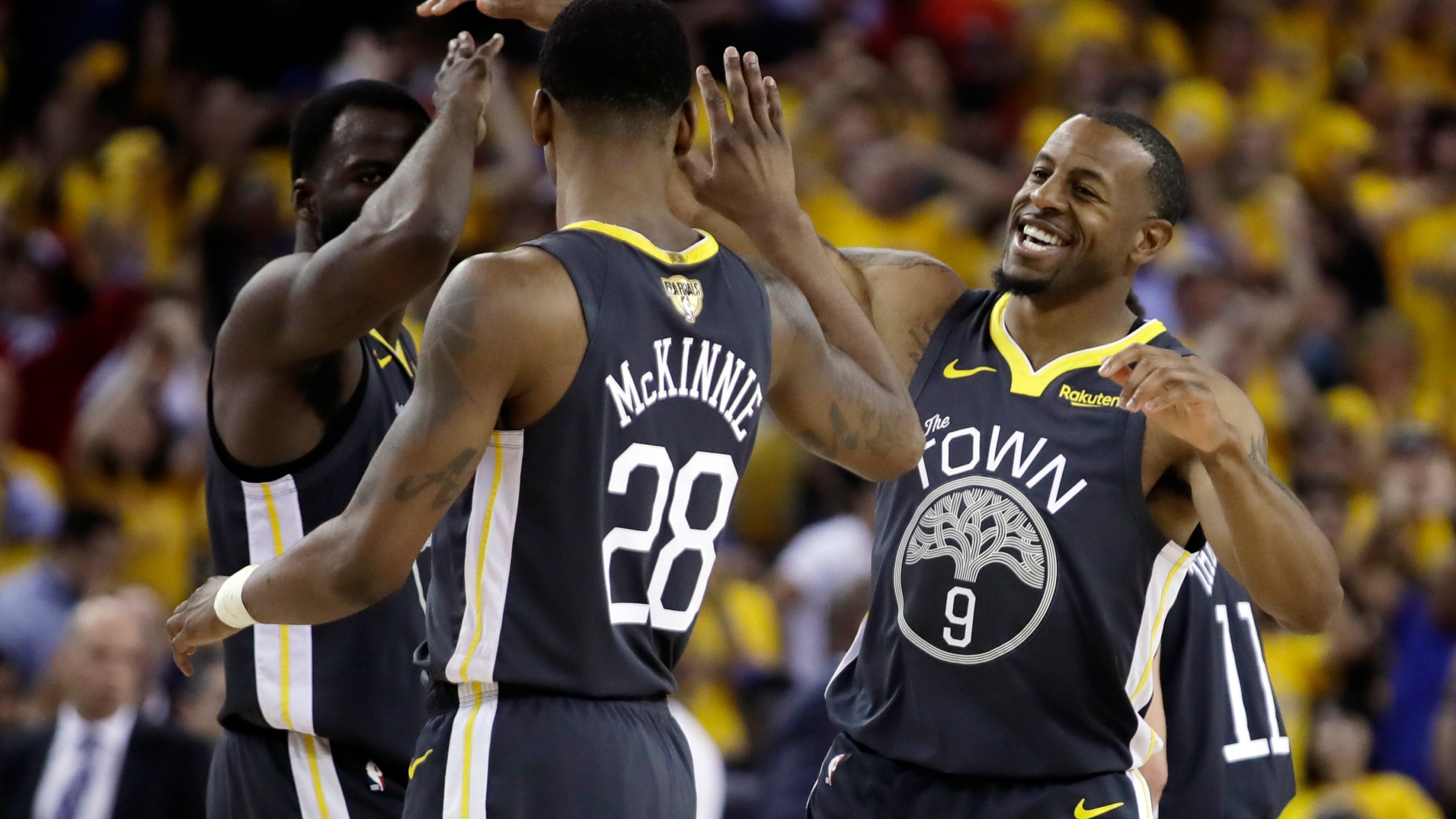 FILE _ Golden State Warriors forward Draymond Green, left, celebrates with forward Alfonzo McKinnie (28) and forward Andre Iguodala (9) during the first half of Game 6 of basketball's NBA Finals against the Toronto Raptors in Oakland, Calif., Thursday, June 13, 2019. (AP Photo/Ben Margot, File)