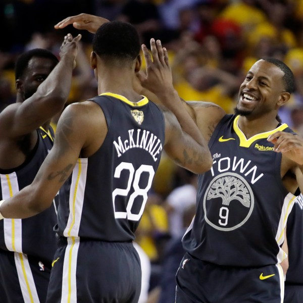 FILE _ Golden State Warriors forward Draymond Green, left, celebrates with forward Alfonzo McKinnie (28) and forward Andre Iguodala (9) during the first half of Game 6 of basketball's NBA Finals against the Toronto Raptors in Oakland, Calif., Thursday, June 13, 2019. (AP Photo/Ben Margot, File)