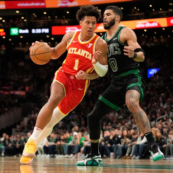 Atlanta Hawks' Jalen Johnson (1) drives by Boston Celtics' Jayson Tatum (0) during the second half of an NBA basketball game, Saturday, Jan. 18, 2025, in Boston. (AP Photo/Robert F. Bukaty)