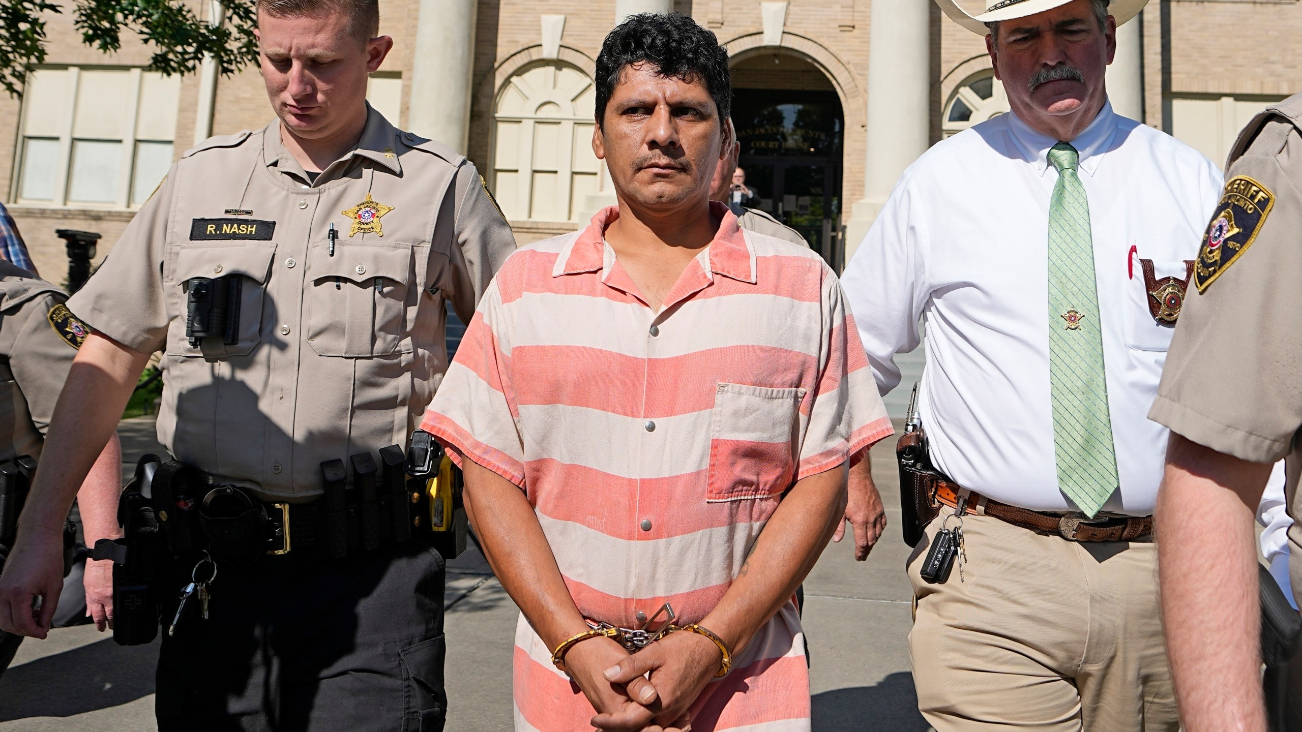 FILE - Francisco Oropeza, center, is escorted from the San Jacinto County courthouse by Sheriff Greg Capers, right, after a hearing May 18, 2023, in Coldspring, Texas. (AP Photo/David J. Phillip, file)