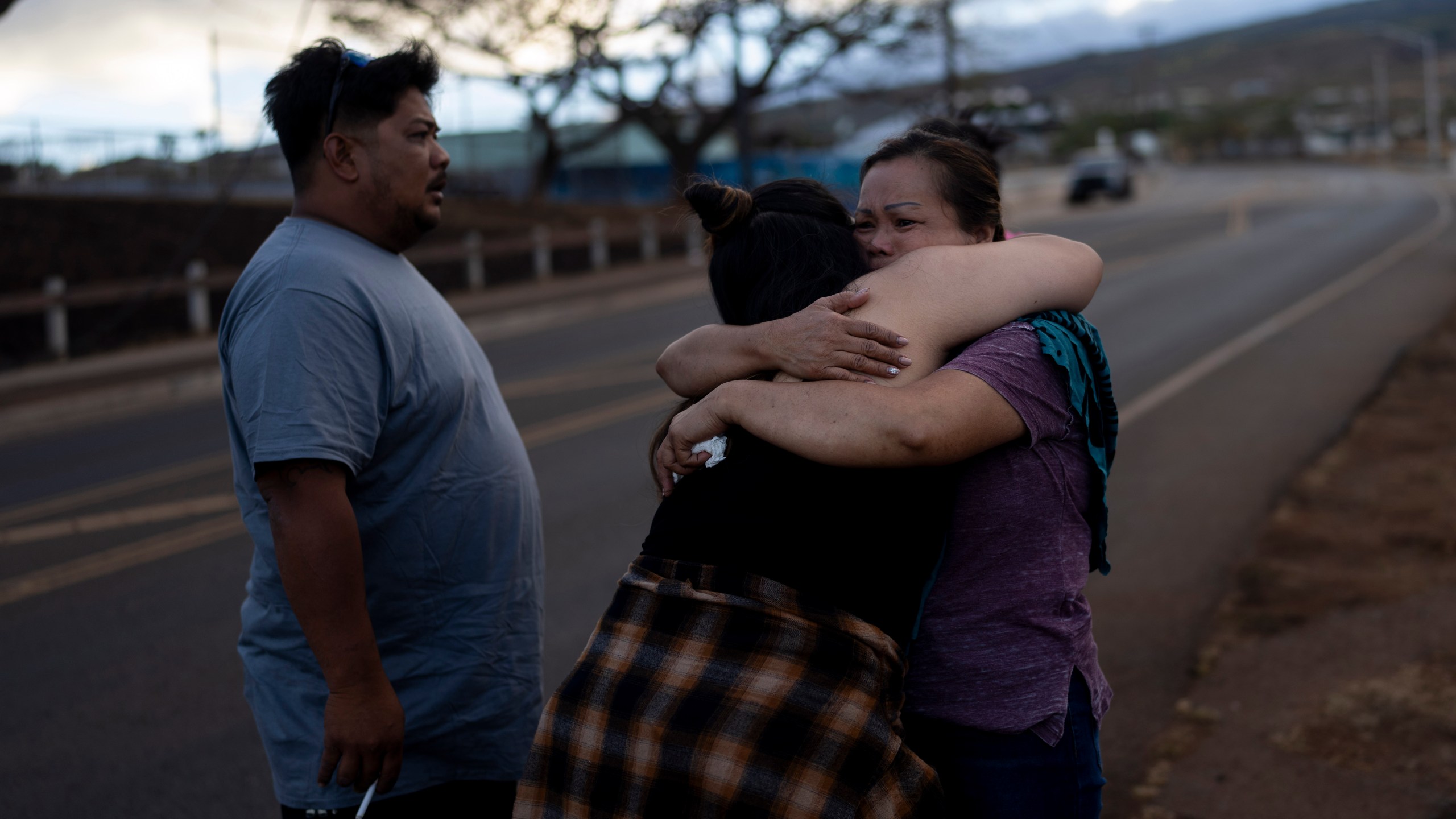 FILE - Nora Bulosan, right, and Hannah Tomas, Lahaina, Hawaii residents who survived the fire that devastated the town, comfort each other as they gather in hopes to get access to their home in Lahaina, Hawaii, Aug. 16, 2023. (AP Photo/Jae C. Hong, File)