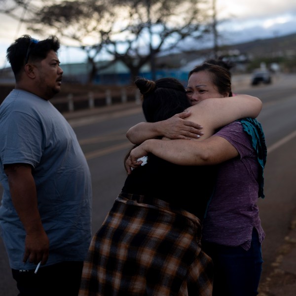 FILE - Nora Bulosan, right, and Hannah Tomas, Lahaina, Hawaii residents who survived the fire that devastated the town, comfort each other as they gather in hopes to get access to their home in Lahaina, Hawaii, Aug. 16, 2023. (AP Photo/Jae C. Hong, File)