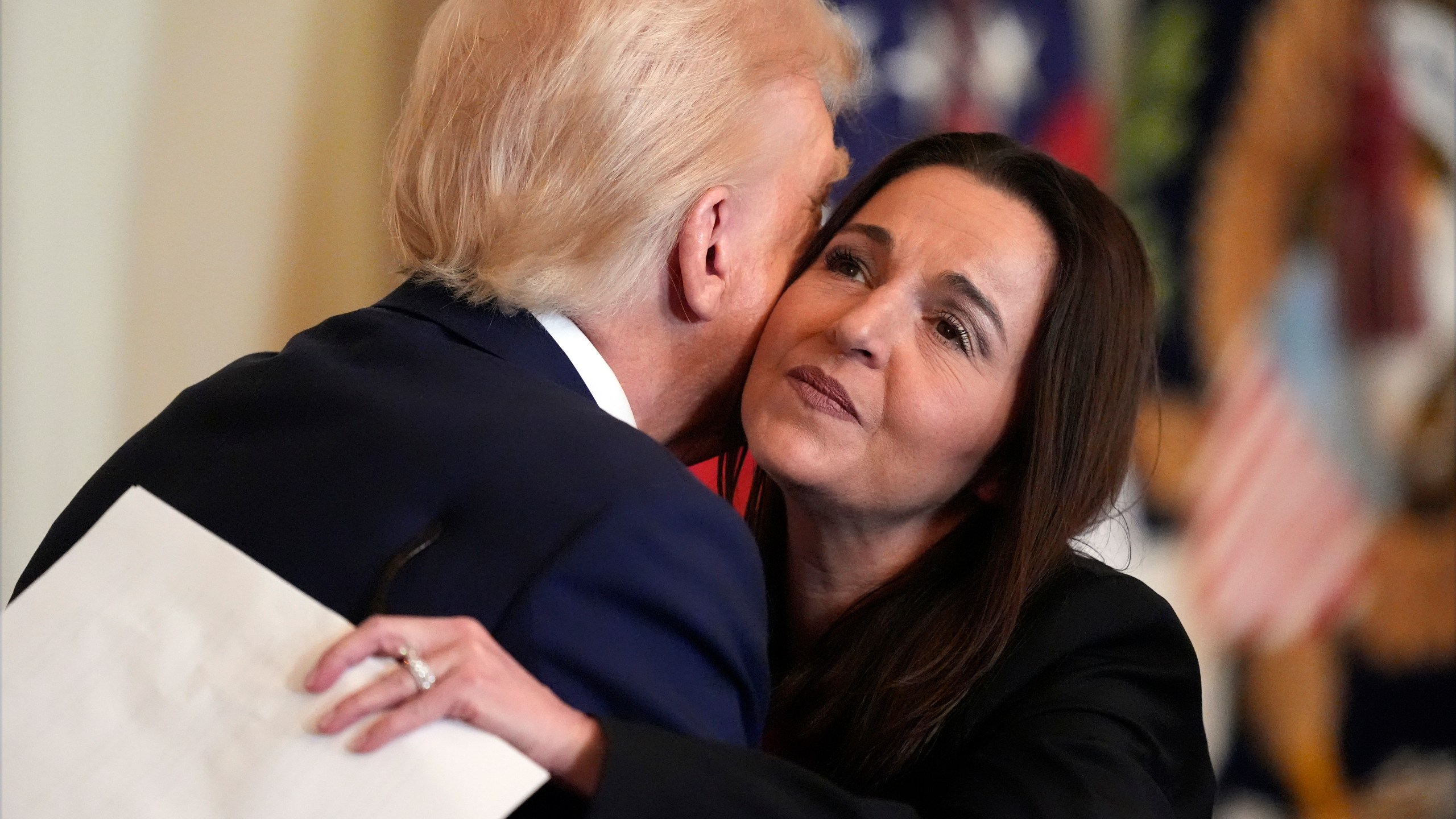 President Donald Trump hugs Allyson Phillips, mother of Laken Riley, before he signs the Laken Riley Act in the East Room of the White House, Wednesday, Jan. 29, 2025, in Washington. (AP Photo/Alex Brandon)