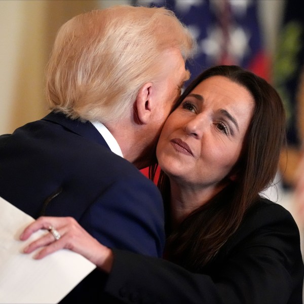 President Donald Trump hugs Allyson Phillips, mother of Laken Riley, before he signs the Laken Riley Act in the East Room of the White House, Wednesday, Jan. 29, 2025, in Washington. (AP Photo/Alex Brandon)