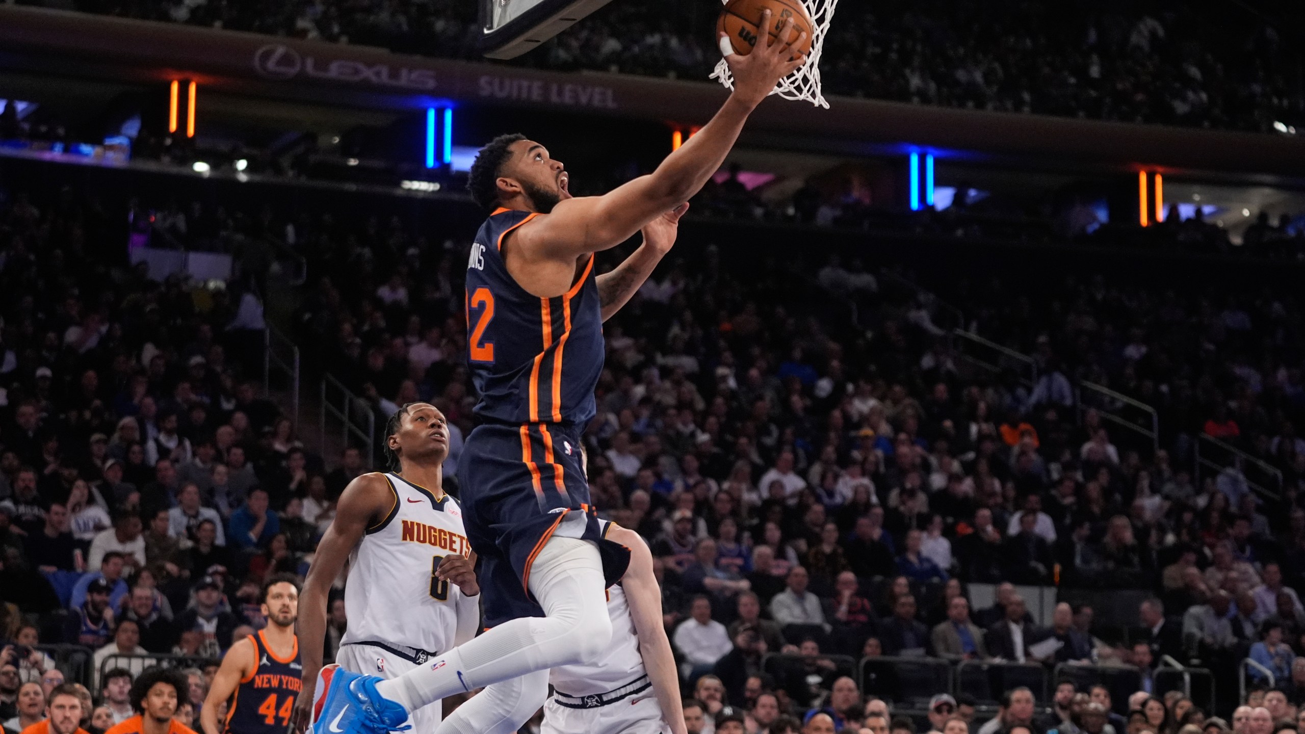 New York Knicks' Karl-Anthony Towns (32) drives past Denver Nuggets' Peyton Watson (8) during the first half of an NBA basketball game Wednesday, Jan. 29, 2025, in New York. (AP Photo/Frank Franklin II)