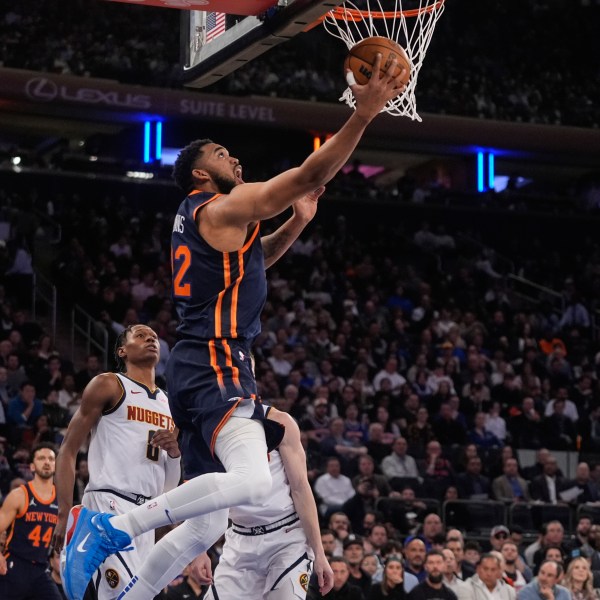 New York Knicks' Karl-Anthony Towns (32) drives past Denver Nuggets' Peyton Watson (8) during the first half of an NBA basketball game Wednesday, Jan. 29, 2025, in New York. (AP Photo/Frank Franklin II)