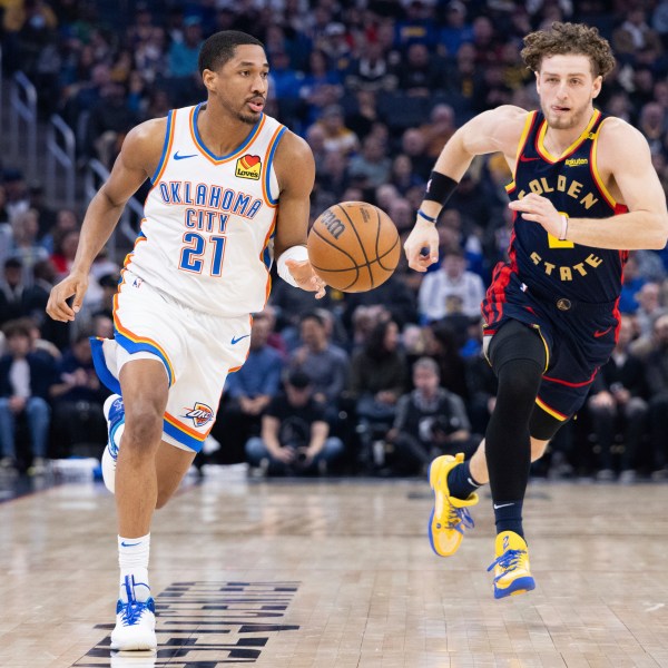 Oklahoma City Thunder guard Aaron Wiggins (21) dribbles past Golden State Warriors guard Brandin Podziemski during the first half of an NBA basketball game Wednesday, Jan. 29, 2025, in San Francisco. (AP Photo/Benjamin Fanjoy)