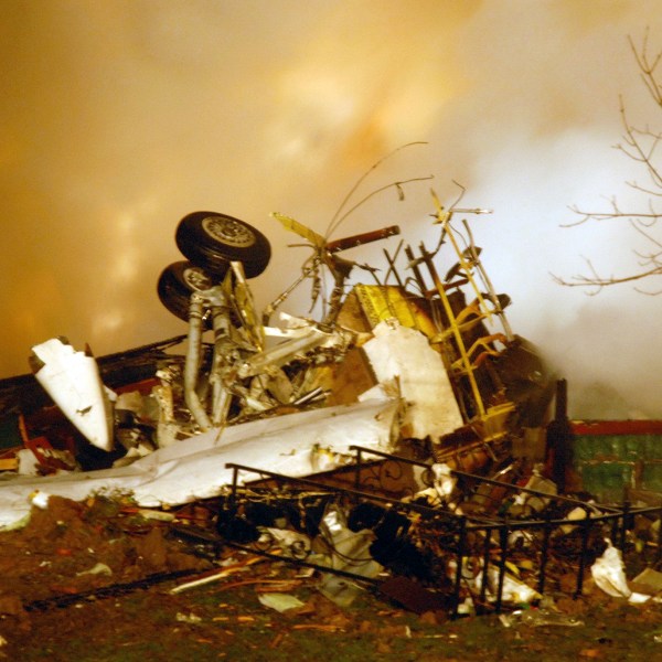 FILE - In this Feb. 12, 2009, file photo, the wreckage of Continental flight 3407 lies amid smoke at the scene after crashing into a suburban Buffalo home and erupting into flames. (AP Photo/Dave Sherman, File)