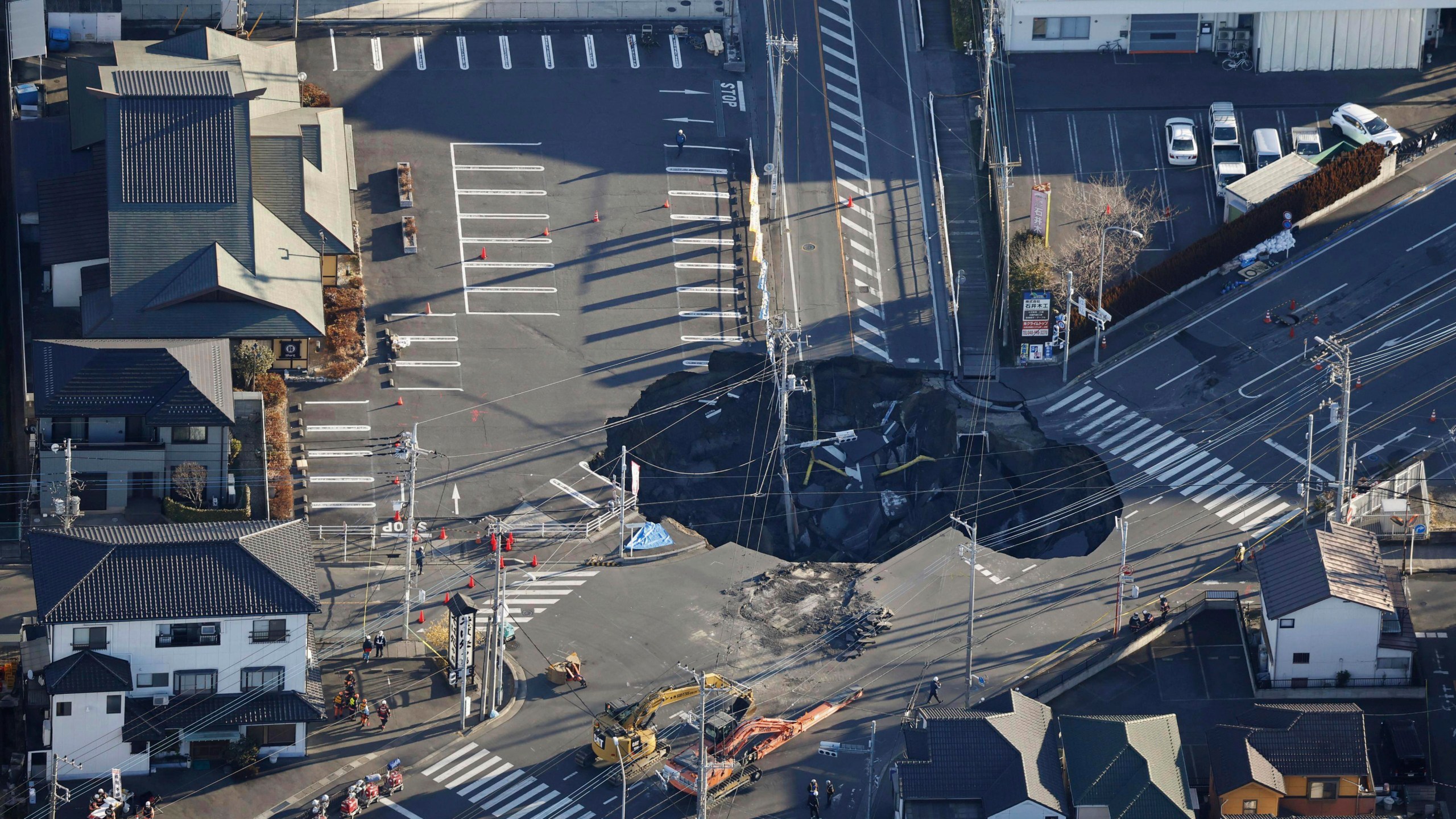 Police officers and rescue members prepare for a rescue mission in Yashio, northeast of Tokyo, Thursday, Jan. 30, 2025, two days after a truck fell into the sinkhole made on a street Tuesday. (Yu Matsuda/Kyodo News via AP)