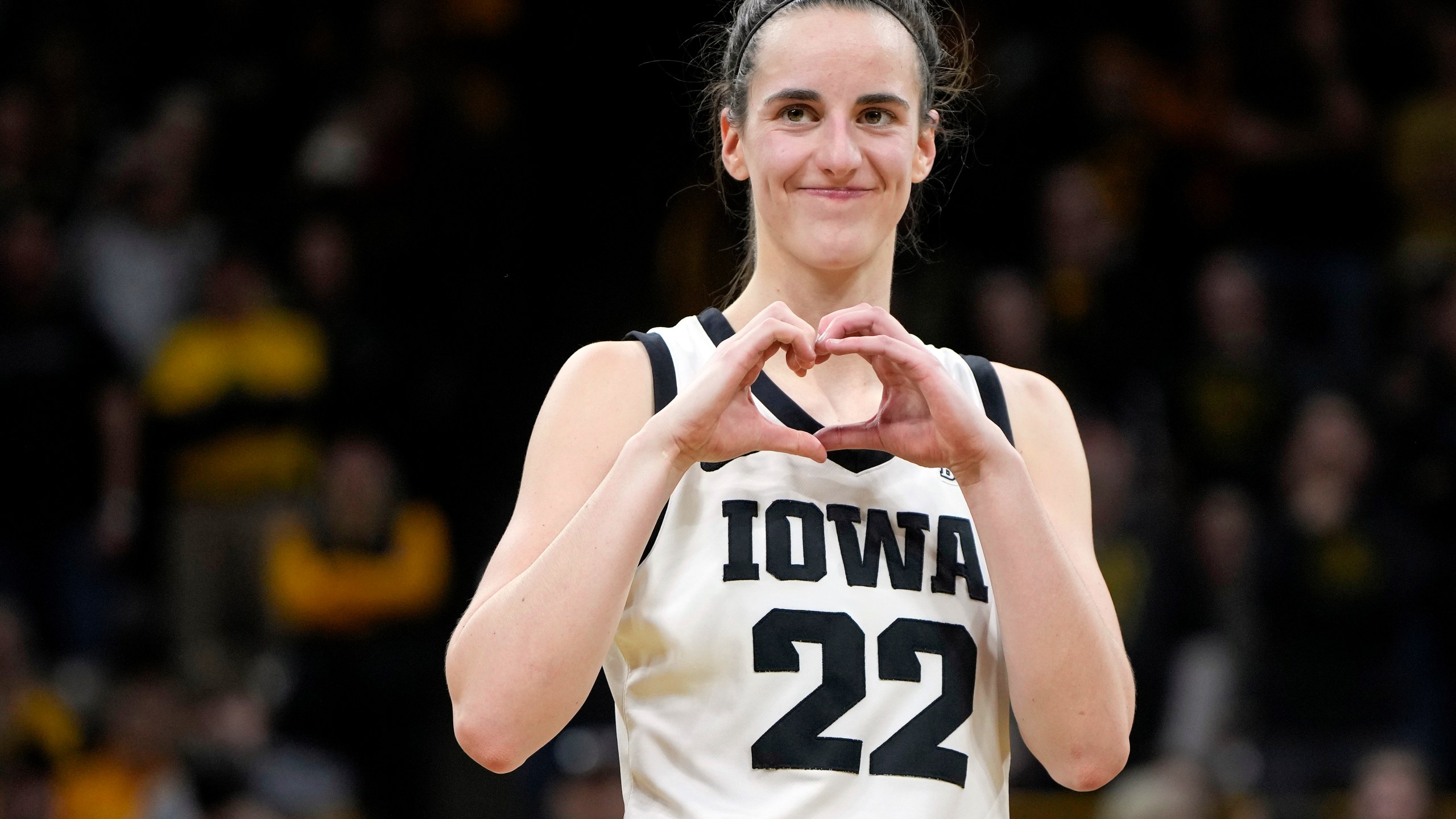 FILE - Iowa guard Caitlin Clark makes a heart gesture after the team's NCAA college basketball game against Michigan, Thursday, Feb. 15, 2024, in Iowa City, Iowa. Clark broke the NCAA women's career scoring record. (AP Photo/Matthew Putney, File)