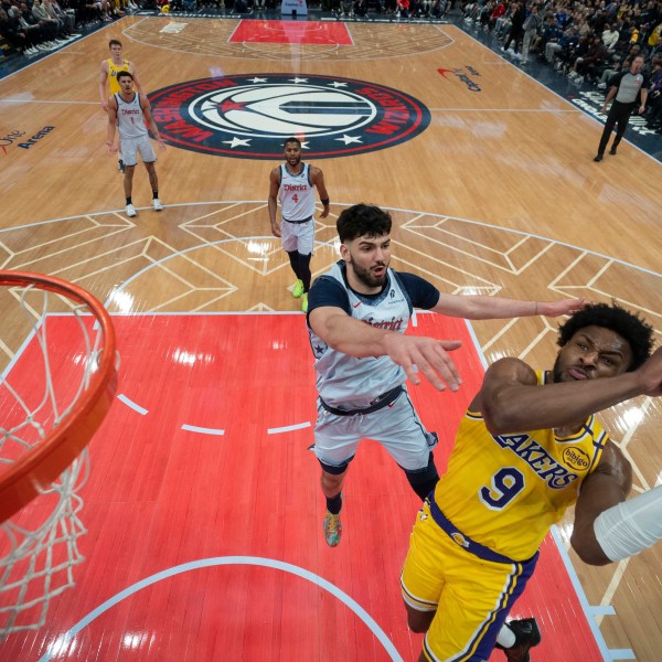 Los Angeles Lakers guard Bronny James (9) goes up to shoot against Washington Wizards forward Tristan Vukcevic, second from front, during the second half of an NBA basketball game Thursday, Jan. 30, 2025, in Washington. (AP Photo/Jess Rapfogel)