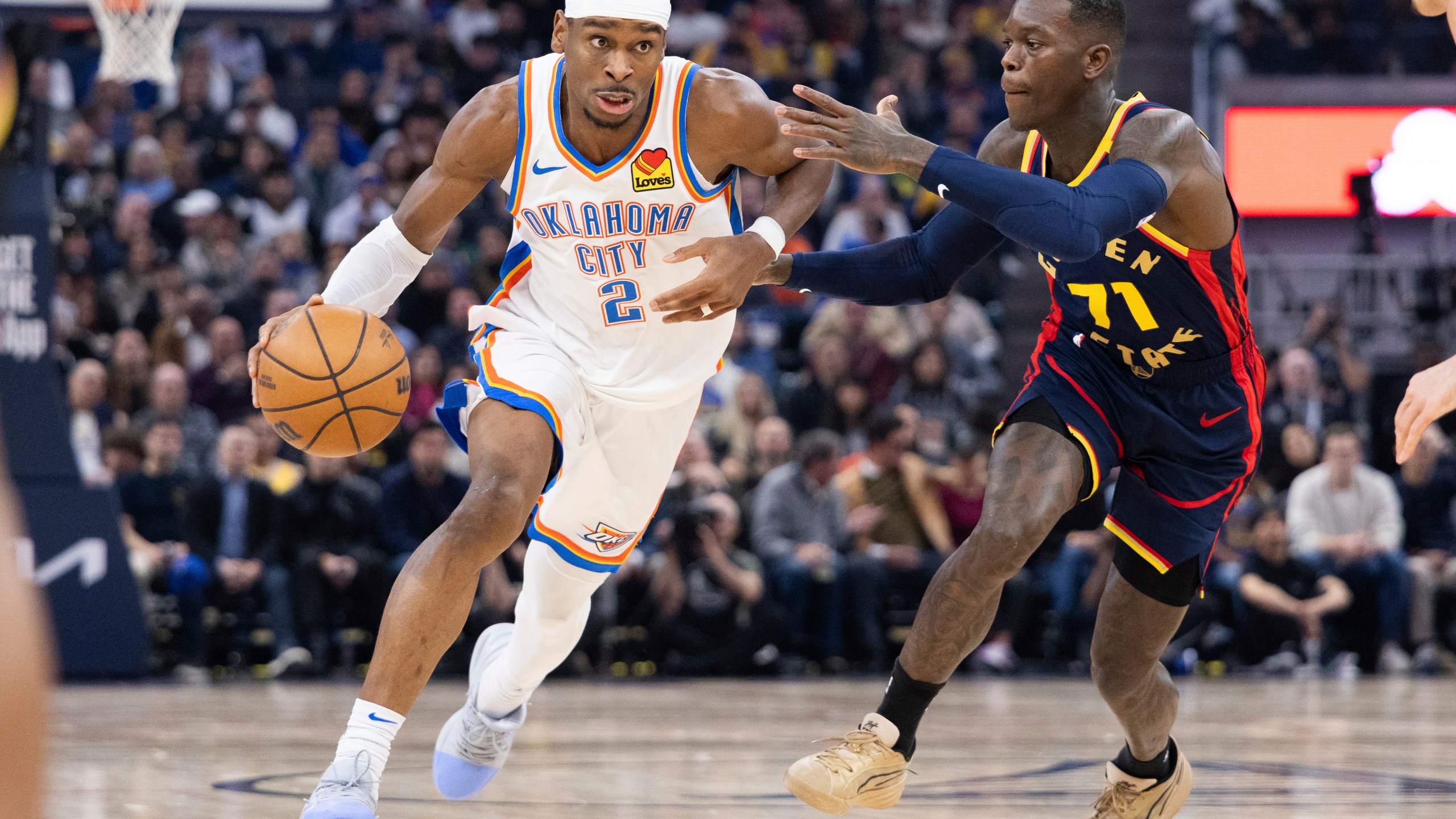 Golden State Warriors guard Dennis Schröder (71) defends against Oklahoma City Thunder guard Shai Gilgeous-Alexander during the first half of an NBA basketball game Wednesday, Jan. 29, 2025, in San Francisco. (AP Photo/Benjamin Fanjoy)