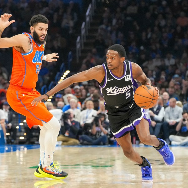 Sacramento Kings guard De'Aaron Fox, right, drives past Oklahoma City Thunder forward Kenrich Williams, left, during the first half of an NBA basketball game, Saturday, Feb. 1, 2025, in Oklahoma City. (AP Photo/Kyle Phillips)