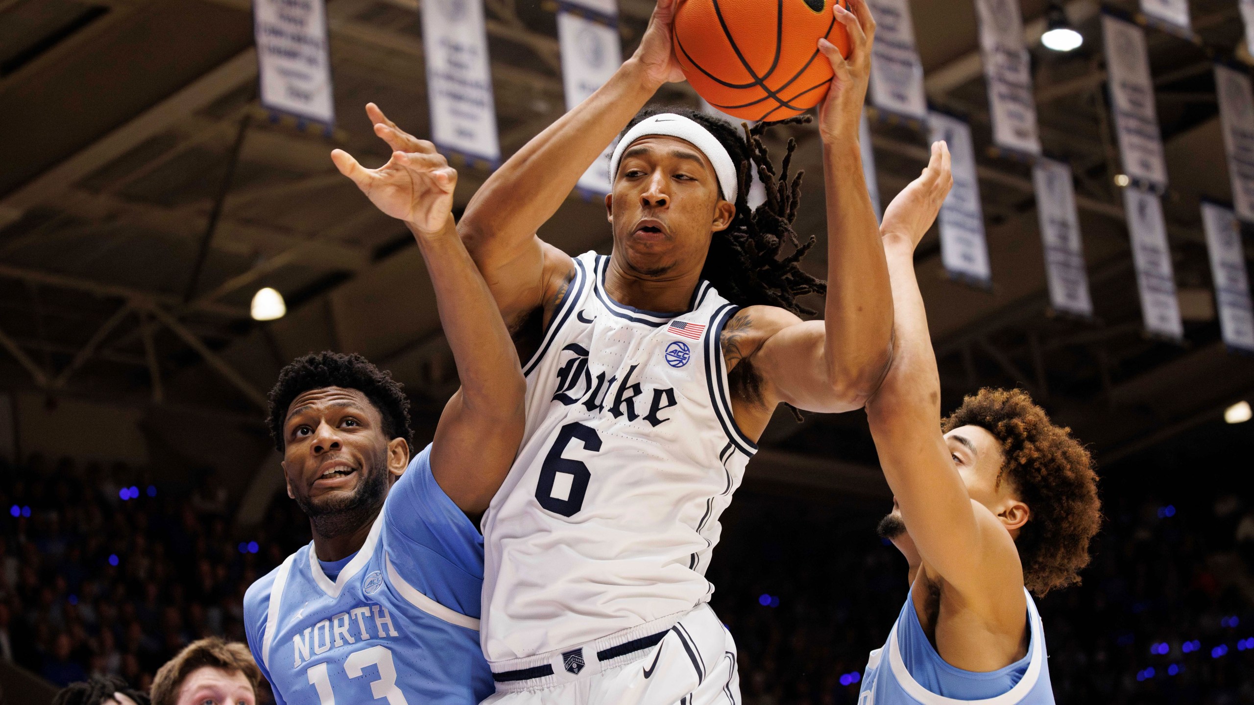 Duke's Maliq Brown (6) grabs a rebound between North Carolina's Jalen Washington (13) and Seth Trimble, right, during the first half of an NCAA college basketball game in Durham, N.C., Saturday, Feb. 1, 2025. (AP Photo/Ben McKeown)