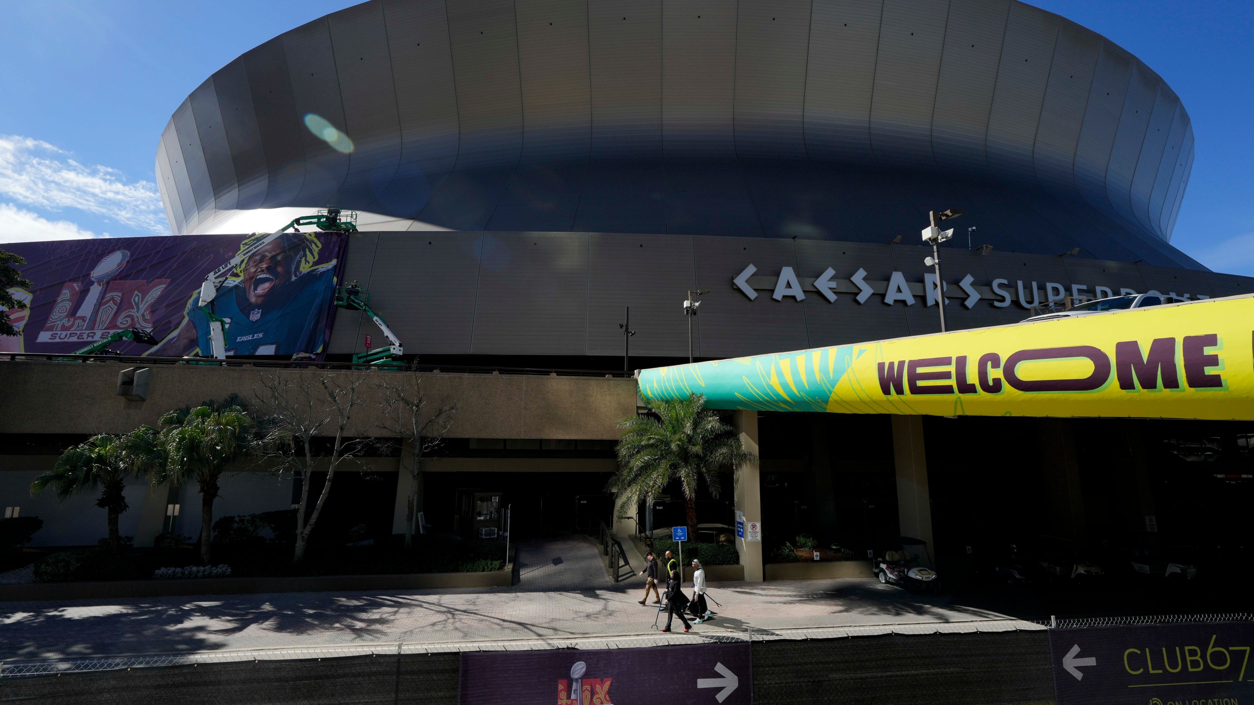 Workers hang player banners outside the Caesars Superdome, Saturday, Feb. 1, 2025, in New Orleans, prior to the NFL Super Bowl 59 football game between the Philadelphia Eagles and the Kansas City Chiefs. (AP Photo/Godofredo A. Vásquez)