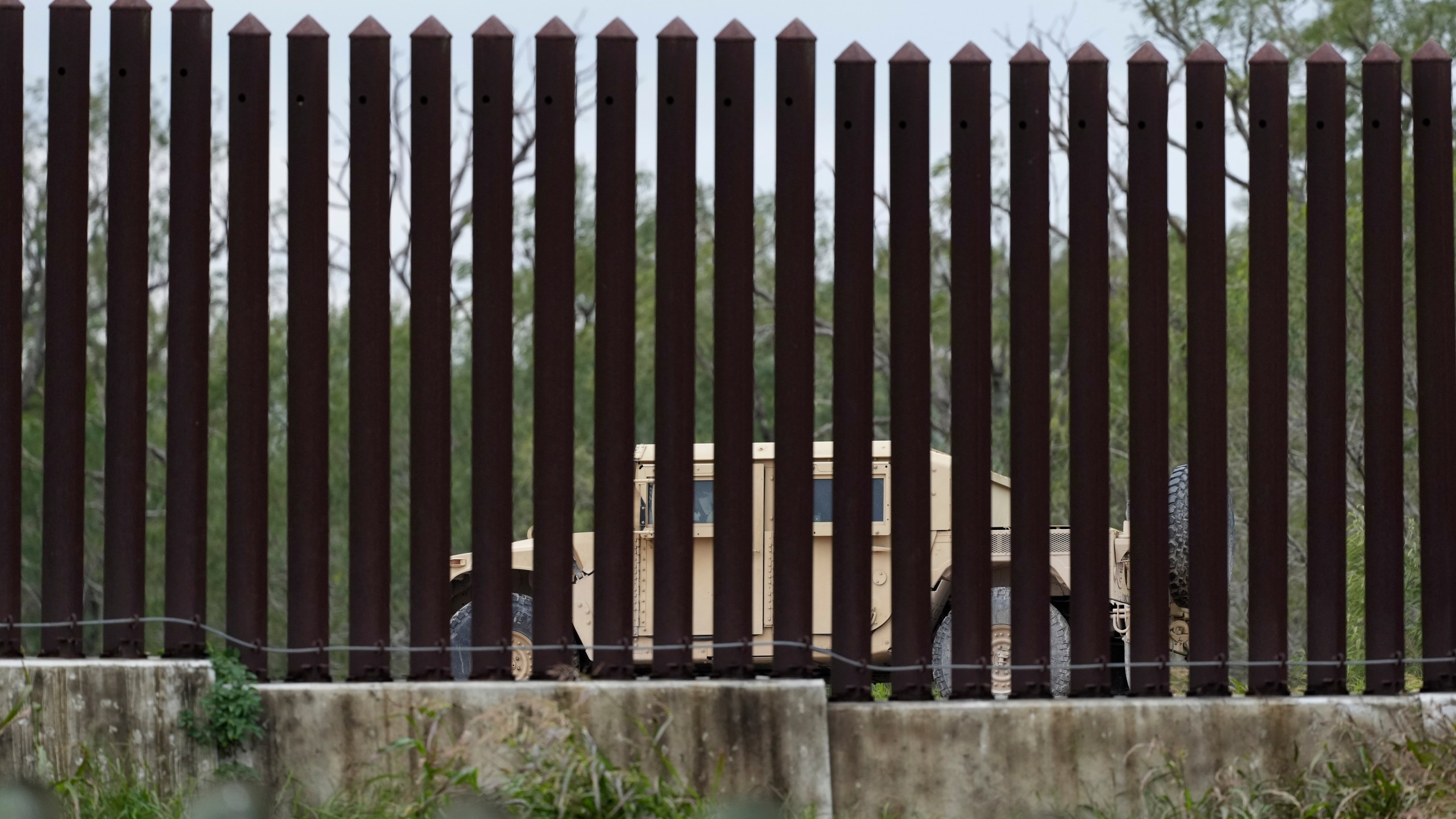 A member of the National Guard patrols along a stretch of border wall, Tuesday, Jan. 21, 2025, in Brownsville, Texas. (AP Photo/Eric Gay)