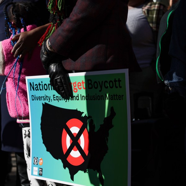 FILE - A community member holds a sign calling for a national boycott of Target stores during a news conference outside Target Corporation's headquarters in Minneapolis, Minn., Jan. 30, 2025. (AP Photo/Ellen Schmidt, File)