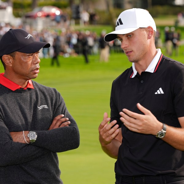 Ludvig Åberg, of Sweden, right, speaks with Tiger Woods after winning the Genesis Invitational golf tournament Sunday, Feb. 16, 2025, in San Diego. (AP Photo/Gregory Bull)