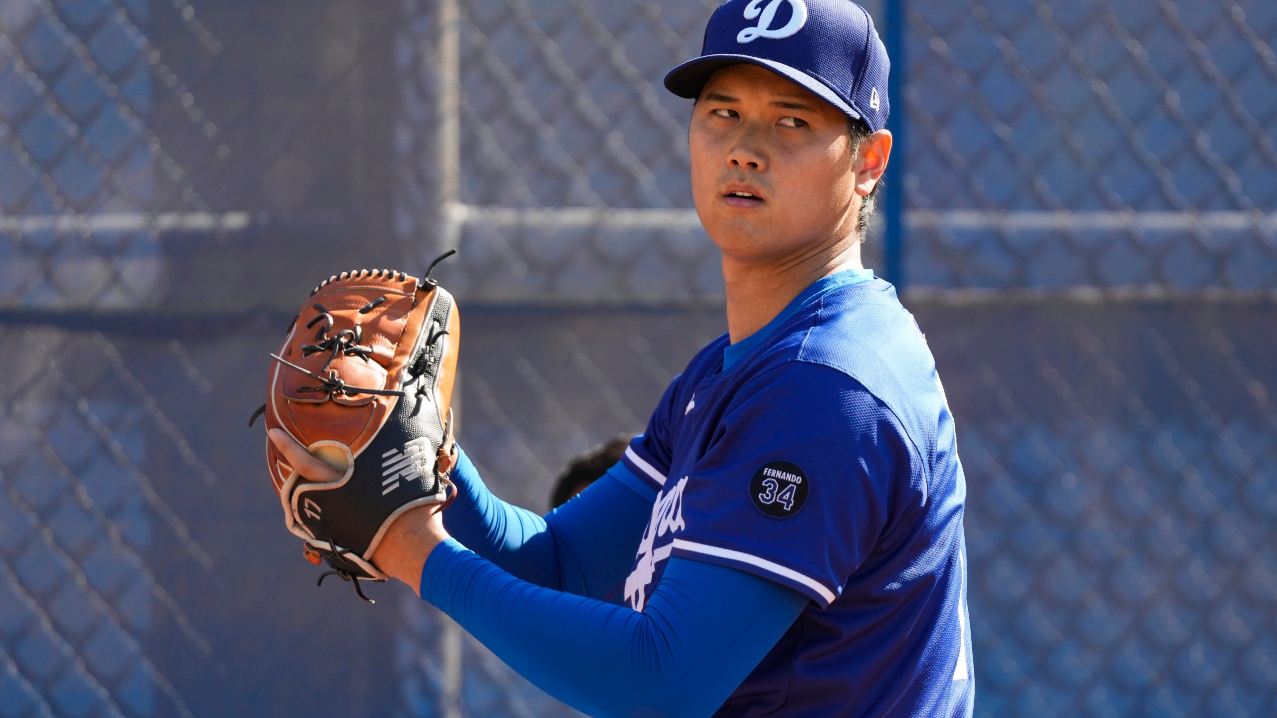 Los Angeles Dodgers two-way player Shohei Ohtani (17) throws in the bullpen during spring training baseball practice, Tuesday, Feb. 18, 2025, in Phoenix. (AP Photo/Ashley Landis)