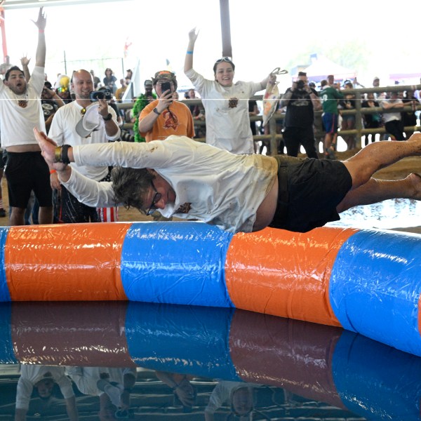 Tom Vars jumps into a pool of water after losing in the Human Beer Pong competition during the Florida Man Games, Saturday, March 1, 2025, in Elkton, Fla. (AP Photo/Phelan M. Ebenhack)