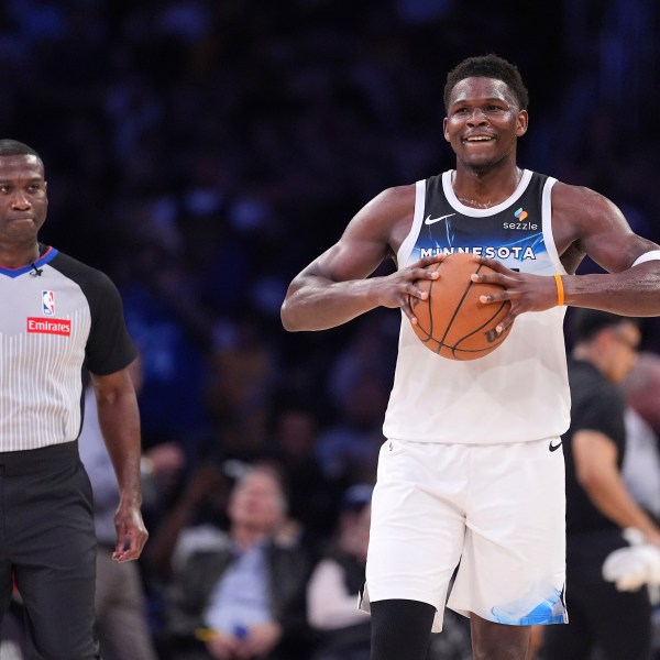 Minnesota Timberwolves guard Anthony Edwards holds the ball as a referee follows after he was ejected during the second half of an NBA basketball game against the Los Angeles Lakers, Thursday, Feb. 27, 2025, in Los Angeles. (AP Photo/Mark J. Terrill)