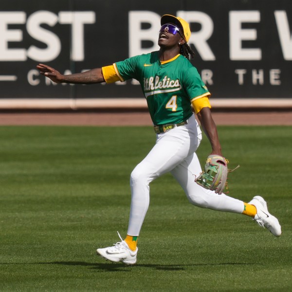 Athletics right fielder Lawrence Butler shouts runs to catch a fly ball hit by Cincinnati Reds' Jeimer Candelario during the second inning of a spring training baseball game, Friday, Feb. 28, 2025, in Mesa, Ariz. (AP Photo/Carolyn Kaster)