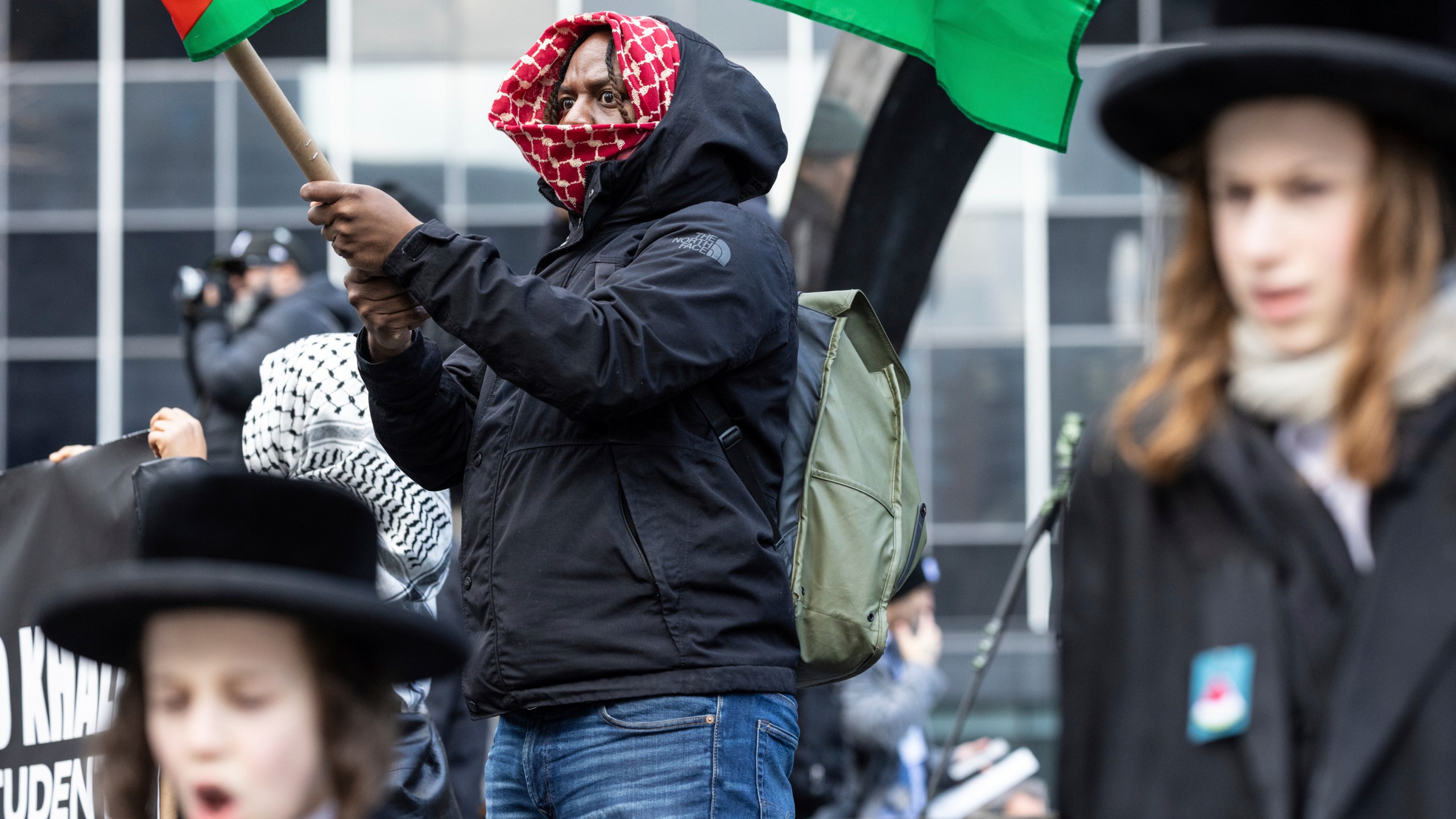 A person waves a Palestinian flag in Foley Square, outside the Manhattan federal court, prior to the deportation case of Mahmoud Khalil, Wednesday, March 12, 2025, in New York. (AP Photo/Stefan Jeremiah)